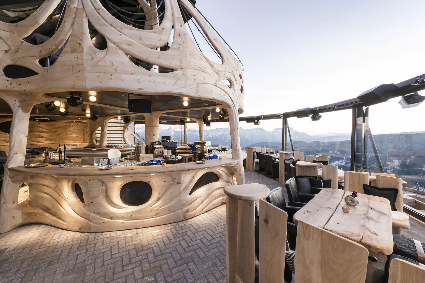 hendl fischerei Modernes Bergrestaurant mit organisch geschwungener Holzarchitektur und Panoramaverglasung, das atemberaubende Berglandschaft im Hintergrund offenbart.