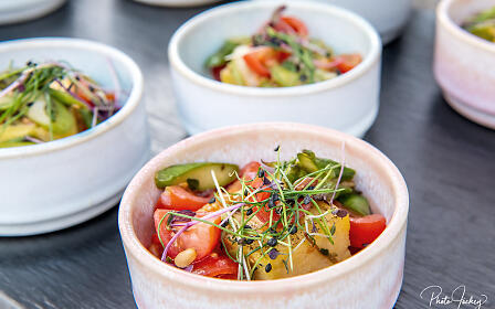 Gemüsesalat mit Tomaten, Kräutern und Zucchini in Keramikschale angerichtet