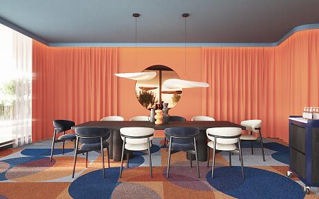 Moderner Konferenz- oder Besprechungsraum mit orangefarbenen Vorhängen, blau-orangefarbener Teppichfläche und einem rechteckigen Holztisch mit verschiedenfarbigen Stühlen.